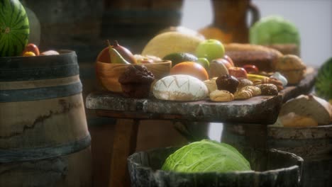 mesa de comida con barriles de vino y algunas frutas, verduras y pan