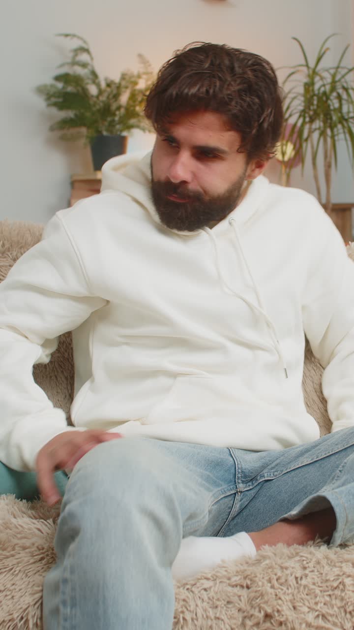 Tired exhausted young indian man freelancer sitting on couch closing laptop in living room at home