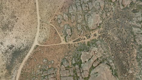 drone flies in bird's eye view over desert landscape in cederberg wilderness area in south africa over an empty road in the desert - drone turns slightly upwards