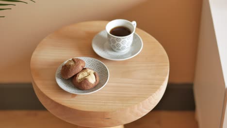 a cup of coffee and cookies on a wooden table