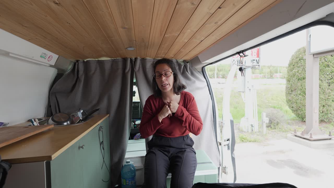 Donna che fa vlogging sulla vera vita in van in un camper van personalizzato.