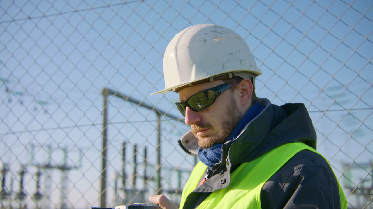 Ingegnere sul posto che comunica con i colleghi tramite walkie-talkie
