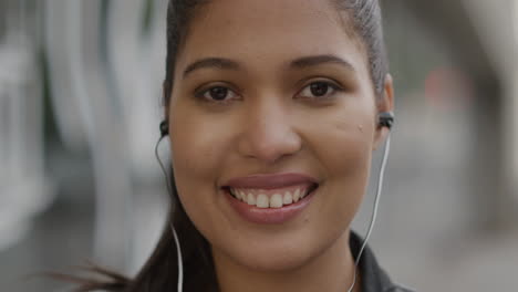 Portrait-of-mixed-race-woman-wearing-headphones-smiling-outdoors