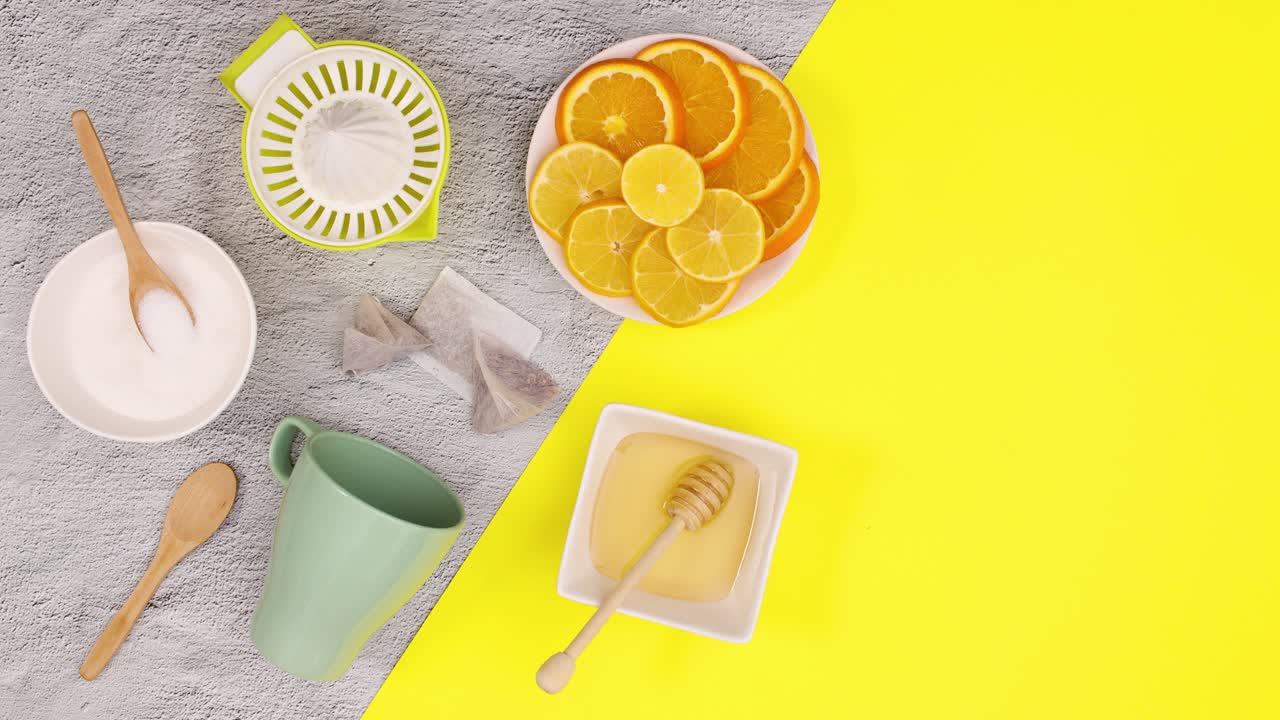 taza de té, limones azúcar, miel aparecen en el tema amarillo. detener el movimiento