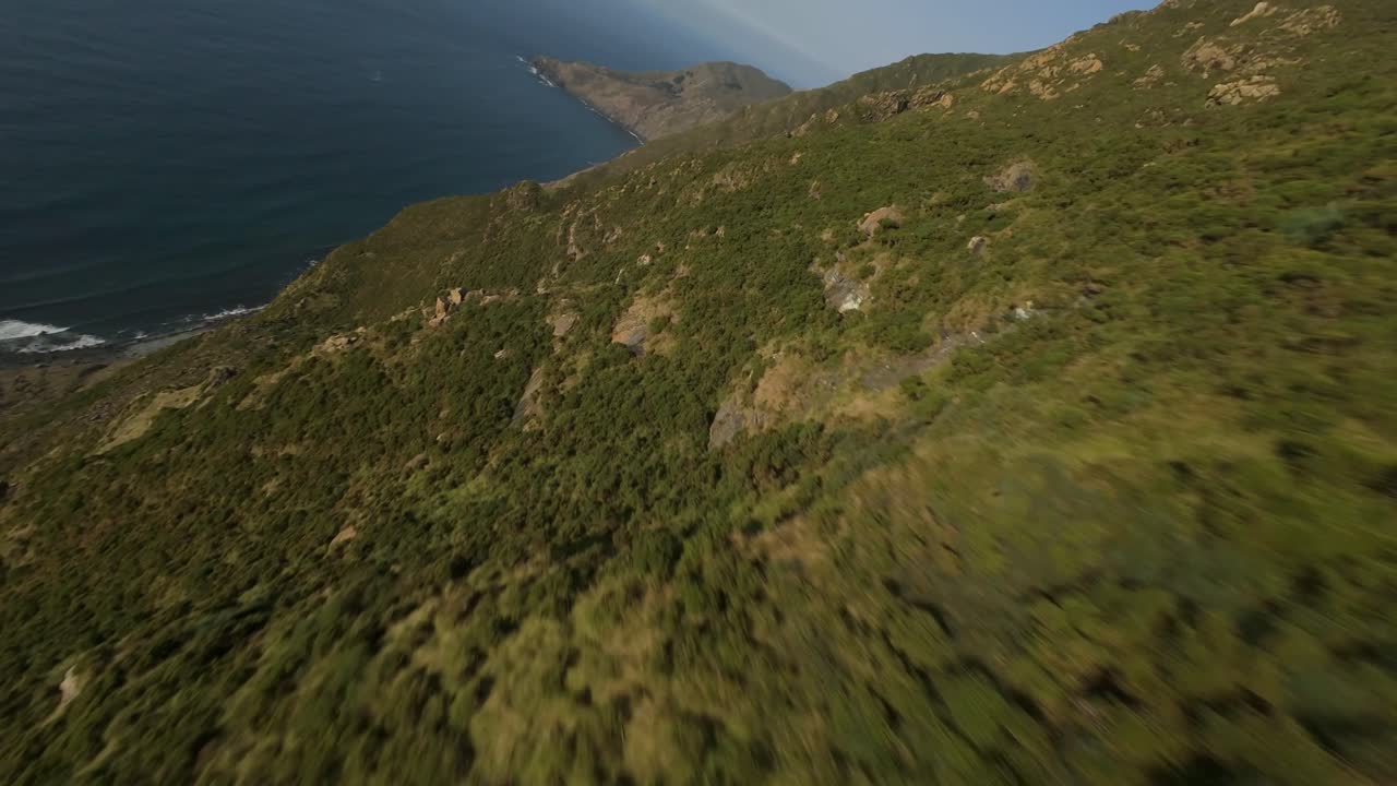 Volo FPV al tramonto sull'oceano, con il sole che scompare all'orizzonte e riflessi dorati sull'acqua, che trasmette libertà, velocità e un'atmosfera tranquilla e cinematografica