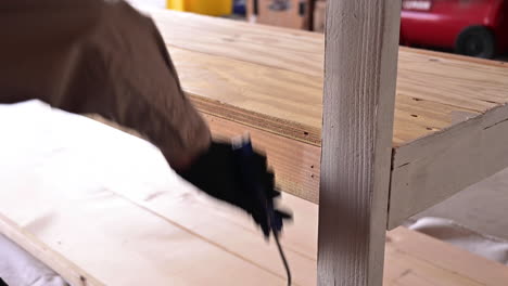 man putting primer paint on table in the garage - close up