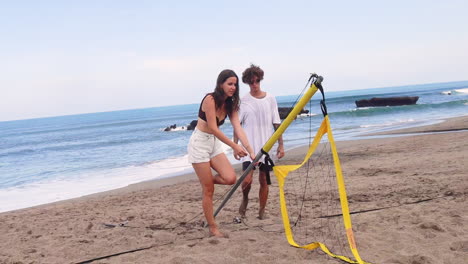 Friends-taking-down-beach-volleyball-net.