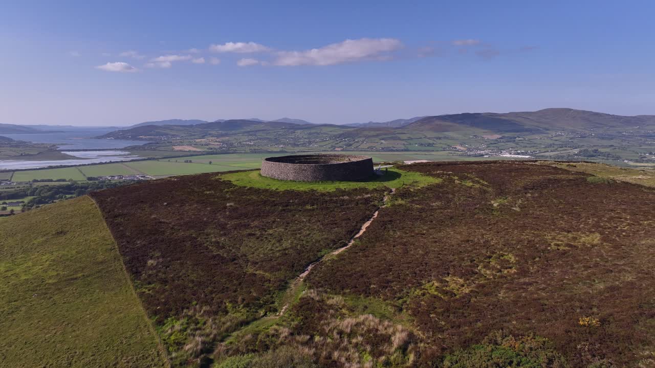 Grianan of Aileach, County Donegal, Ireland, June 2023. Drone aerial flyover pushes forward over the stone ringfort at Inishowen revealing the view north to Inch Wildfowl Reserve and Lough Swilly.
