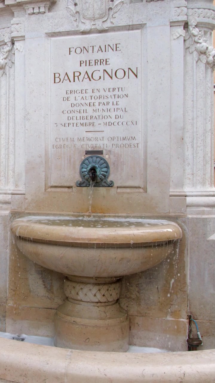 Inquadratura media statica di acqua che scorre da una fontana in pietra intagliata a Cassis, Francia.