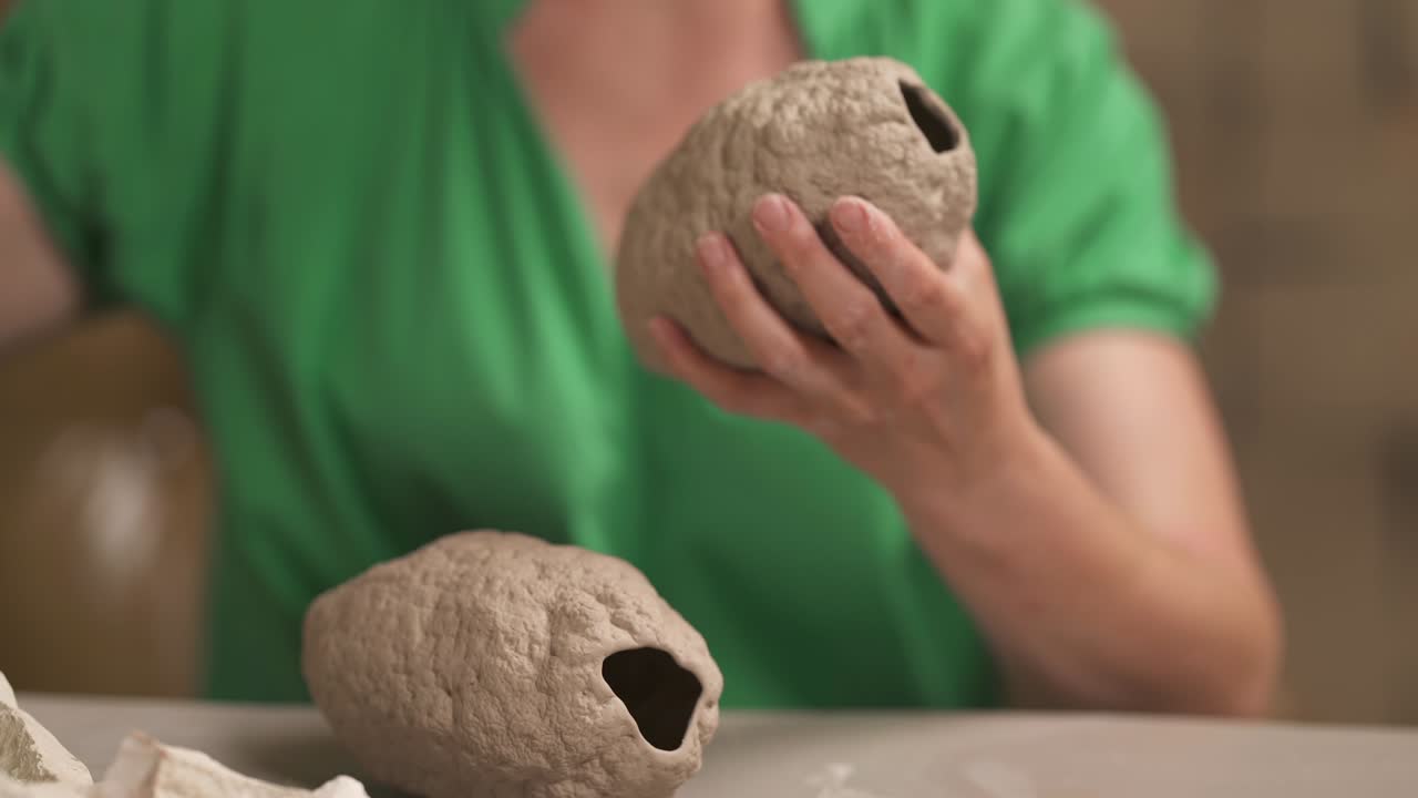 un alfarero pegando cuidadosamente los detalles de una estatua de cerámica. artista profesional trabajando. aislado, en el fondo.
