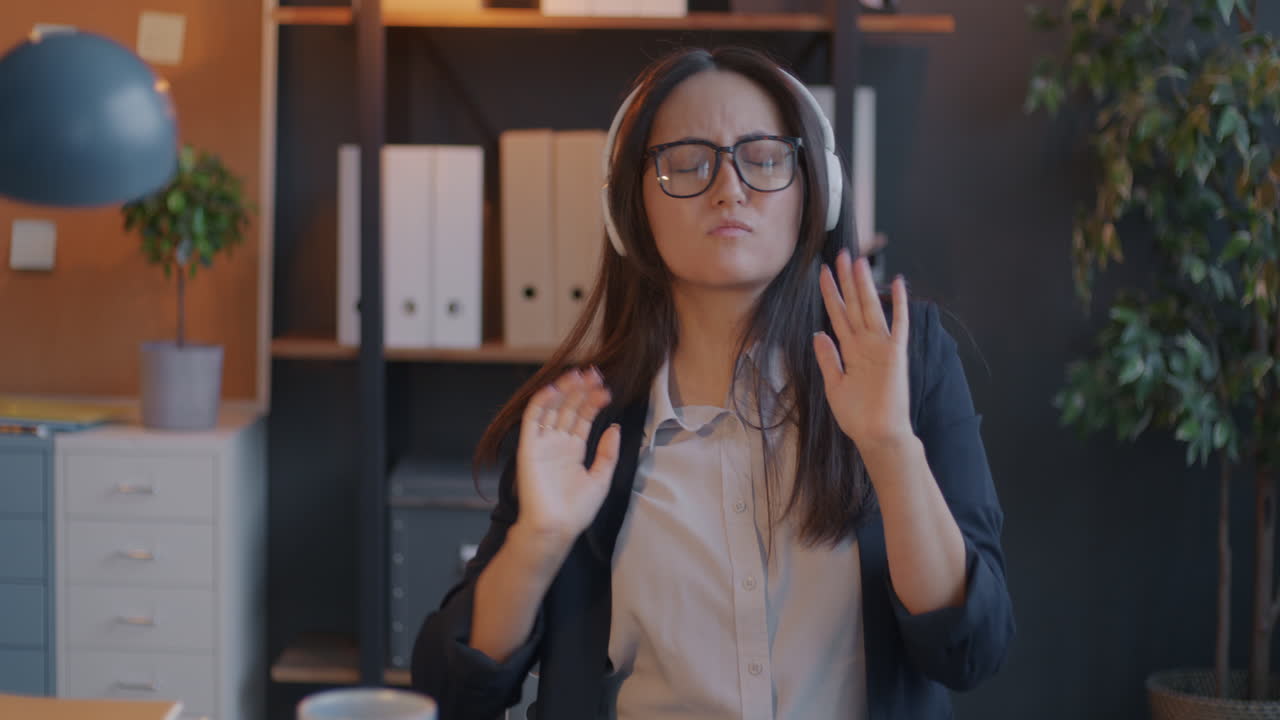 Woman listening to music and dancing in office