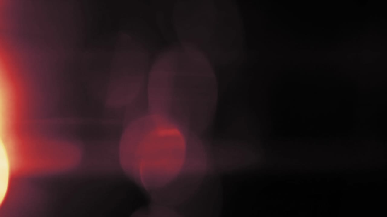 Gentle red light leak from left side with soft, blurry bokeh elements. Use for dreamy, romantic, or nostalgic video projects