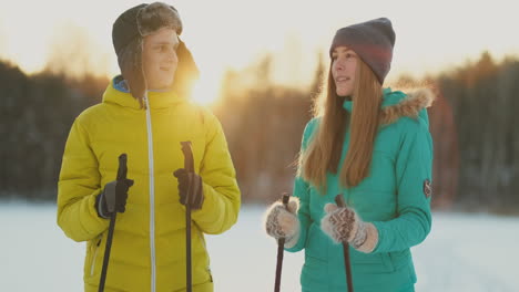 En-El-Bosque-De-Invierno-Al-Atardecer,-Una-Pareja-Amante-De-Esquiar-Y-Contemplar-La-Belleza-De-La-Naturaleza-Y-Las-Atracciones-En-Cámara-Lenta.