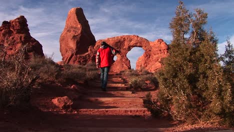 a photographer approaches turret arch in arches national park utah