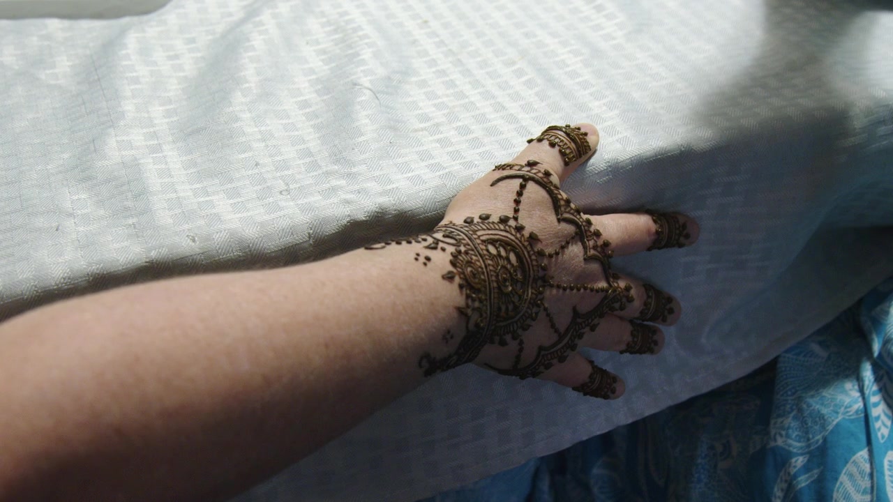Disegni all'henné intricati e ornati applicati sul dorso della mano, arte mehndi.