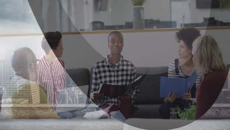 Digital-composite-image-of-multiracial-colleagues-discussing-in-modern-office,-city-in-foreground