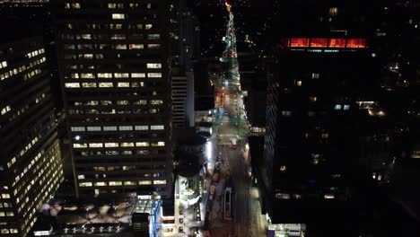 Aerial-flyover-through-buildings-of-Toronto-Canada-street-at-night-time