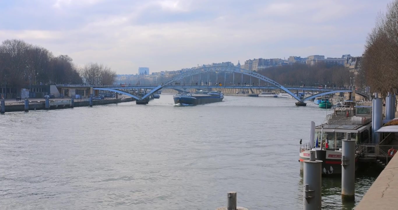 Lastepram som seiler på Seinen under Debilly gangbro i Paris, Frankrike. – vidvinkel.