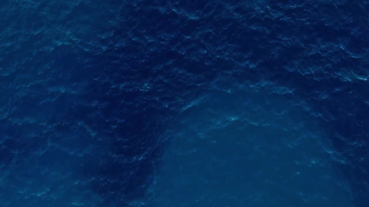 Vista aérea de um corpo d'água na Albânia mostrando tons de azul profundo
