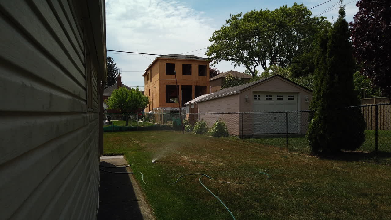 Wide time-lapse of backyard sprinkler and yard