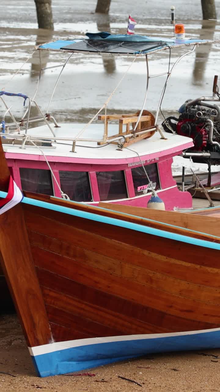 los barcos de cola larga de madera con colores vibrantes atracados en un muelle de phuket. la iluminación nublada crea una atmósfera serena y tranquila