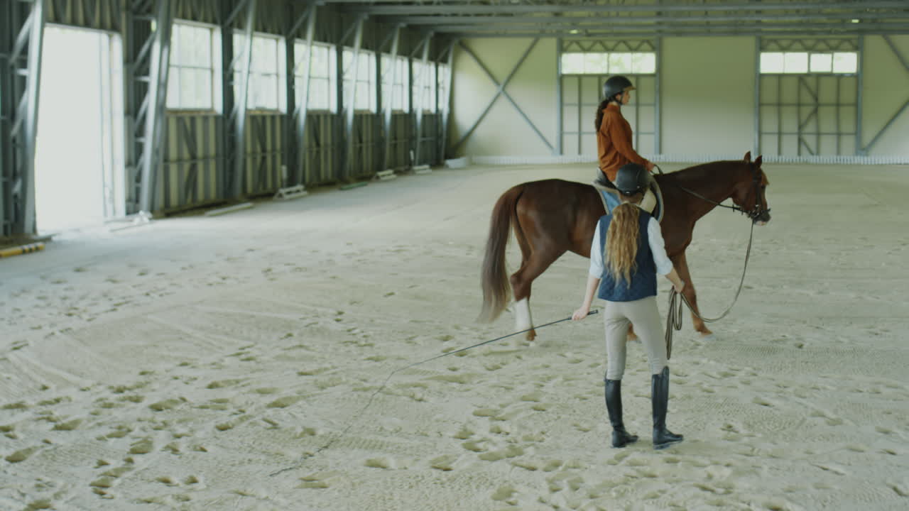 Horse Riding Lesson in an Indoor Equestrian Arena