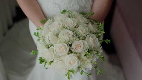 close-up of a bride holding a bouquet of white roses