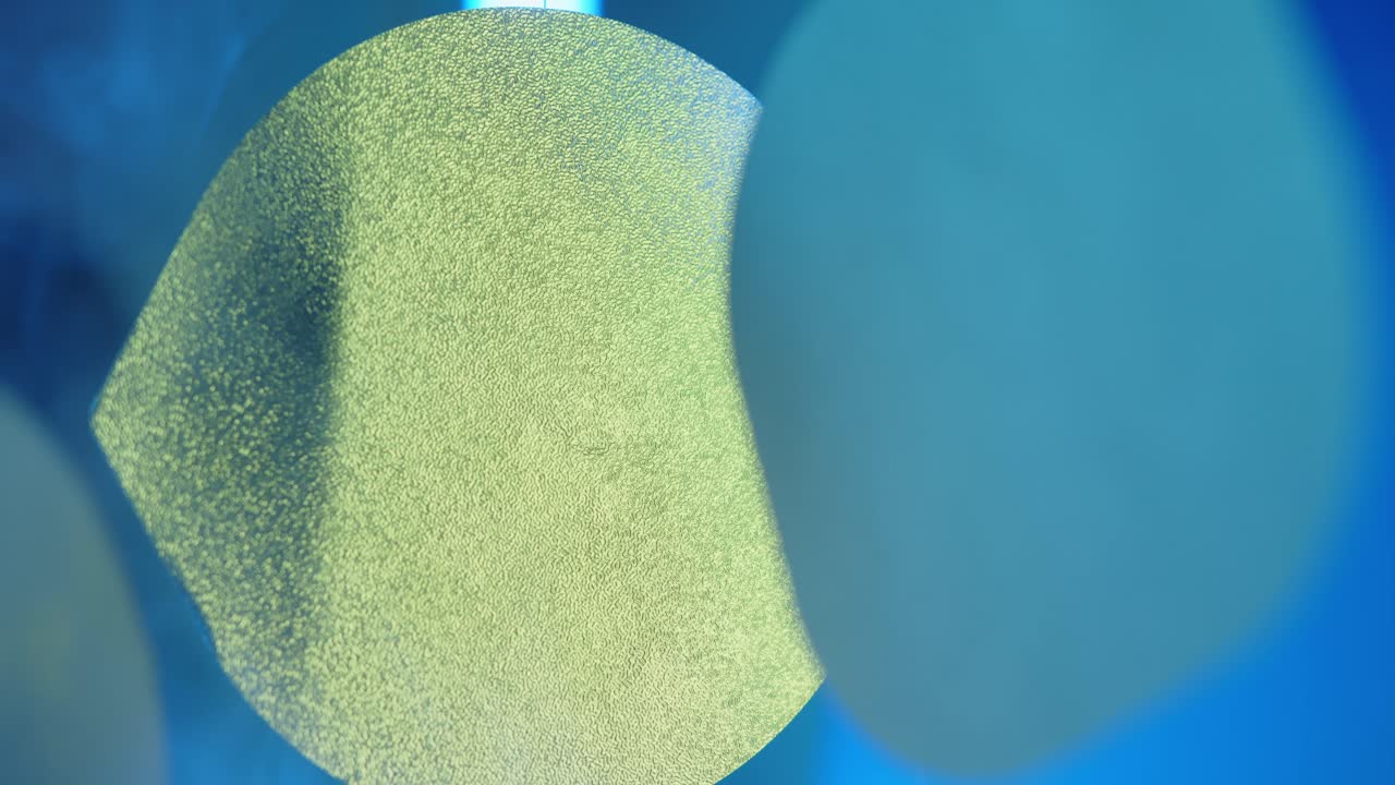 알록달록한 빛의 스펙트럼과 배경의 연기구름에서 매달려 움직이는 알루미늄 뚜껑