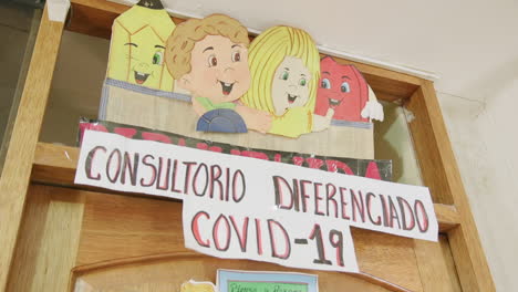 un cartel fuera de una sala de consulta dedicada a pacientes de covid-19 durante la pandemia en ollantaytambo, perú.