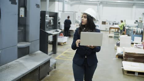 Front-view-of-serious-project-manager-walking-with-laptop