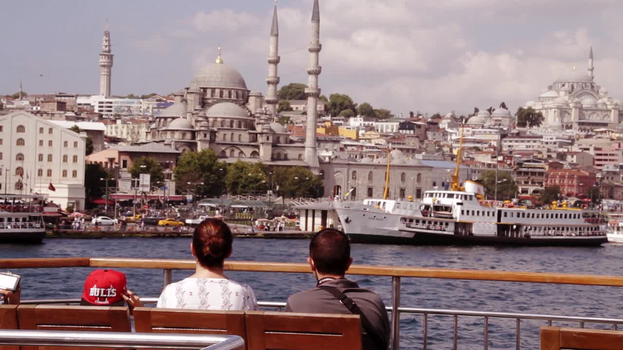 A family watching old city of Istanbul and the Suleymaniye mosque from a departing boat