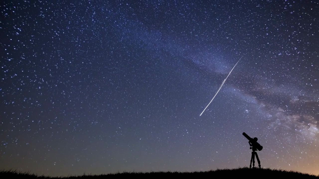Astrónomo observando lluvia de meteoros bajo la Vía Láctea