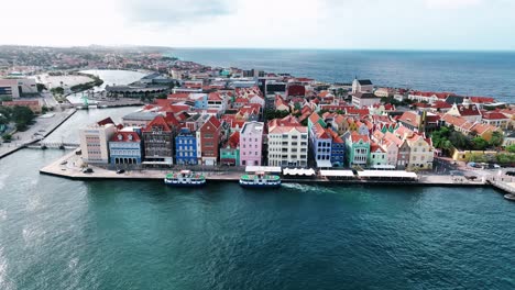 el dron está volando alrededor de las viejas casas coloridas en el muelle comercial en willemstad curacao imágenes aéreas 4k