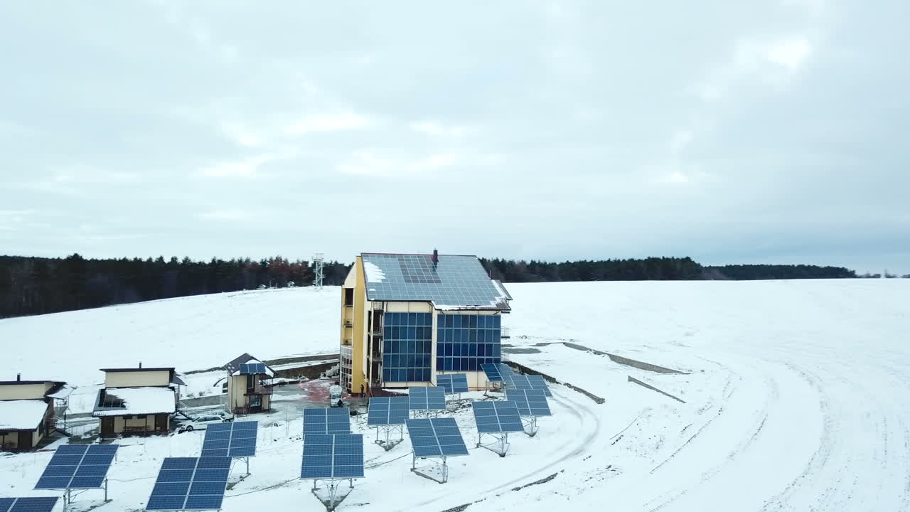 Aerial solar farm low flight in winter. Series of solar panels covered with snow.