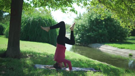 woman doing supported headstand in park