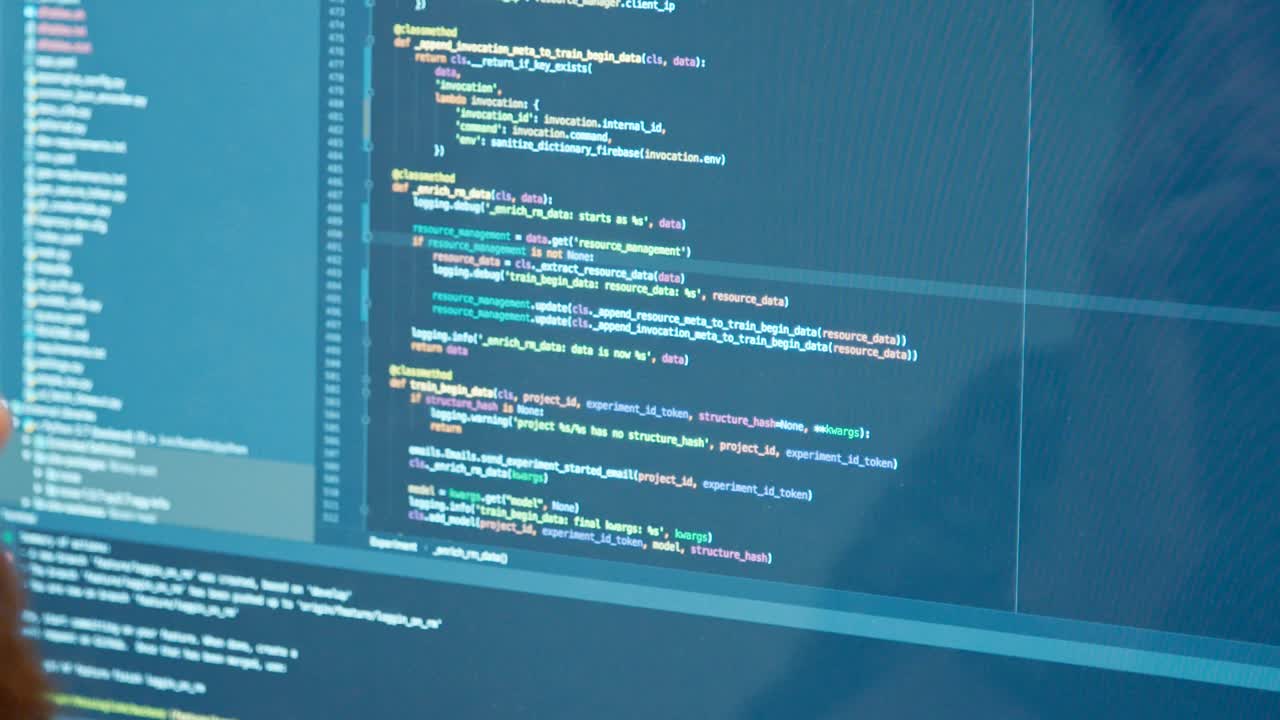 programador de computadora sentado frente a una pantalla codificando software