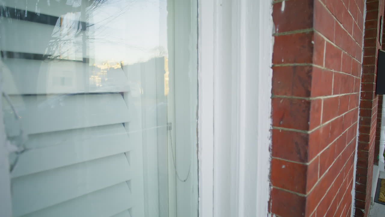 Gimbal shot of the outside of a window in a brick house
