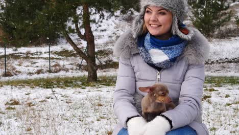 woman playing with her little dog outside winter