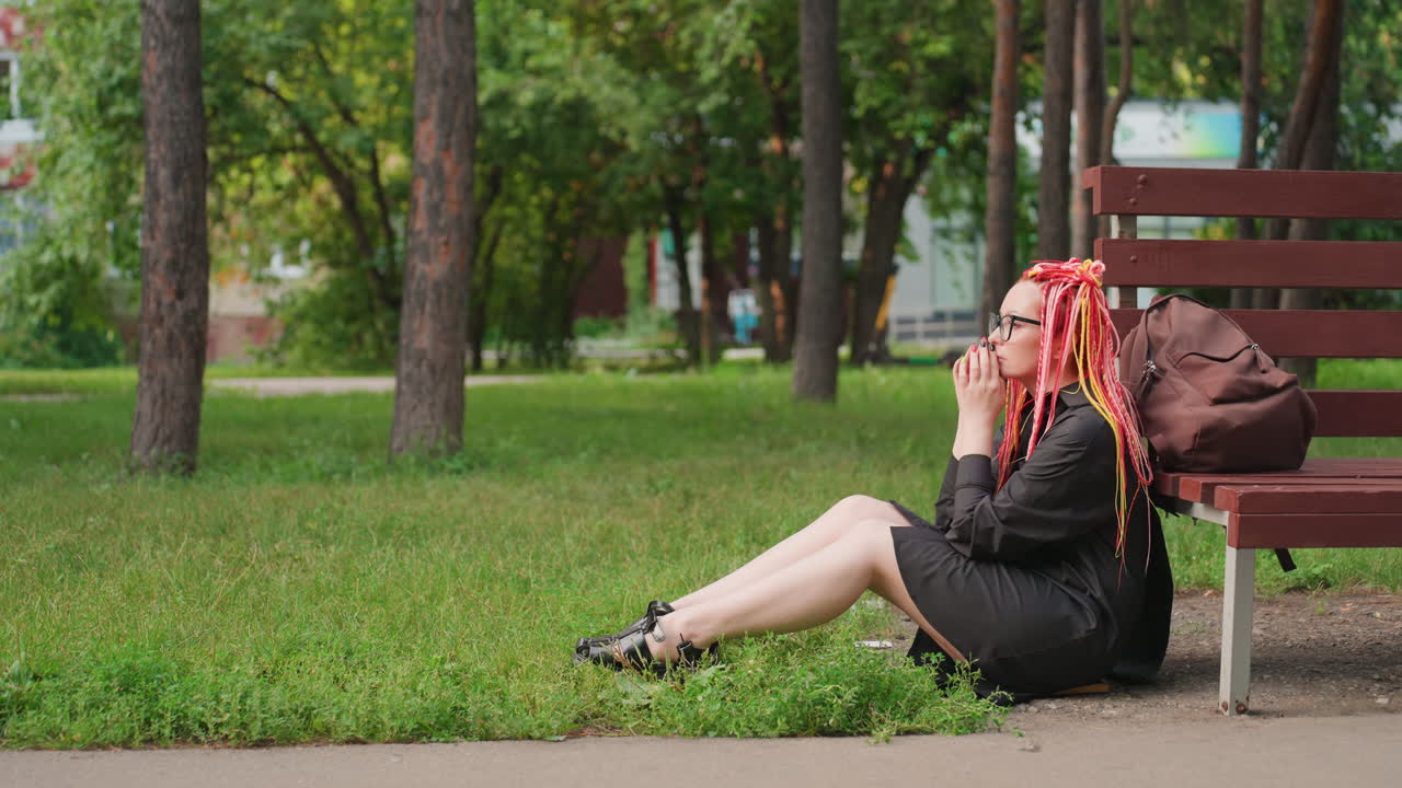 공원에 있는 압도된 여성, 바쁜 하루를 보낸 후 공원 벤치에 앉아 있는 다채로운 머리의 백인 소녀, 힘든 통근 후 공원 벤치 근처에서 휴식을 취하는 생생한 드레드락을 한 젊은 백인 여성