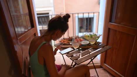 woman enjoying a meal on a balcony with city view