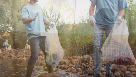 animation of grass over two caucasian men collecting rubbish in forest high fiving