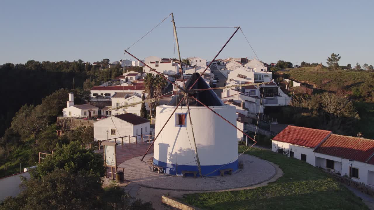 volar hacia el típico viejo molino de viento en odeceixe, portugal, desde el aire