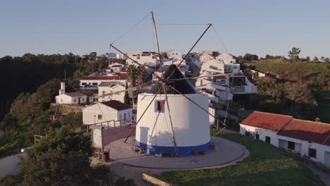 fly towards typical old windmill at odeceixe portugal, aerial