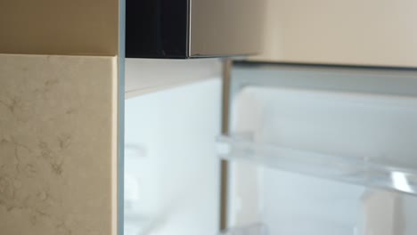 person opening a black modern refrigerator in a modern kitchen