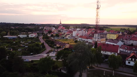 ciudad rural con iglesia histórica, casas antiguas y torre de radio moderna