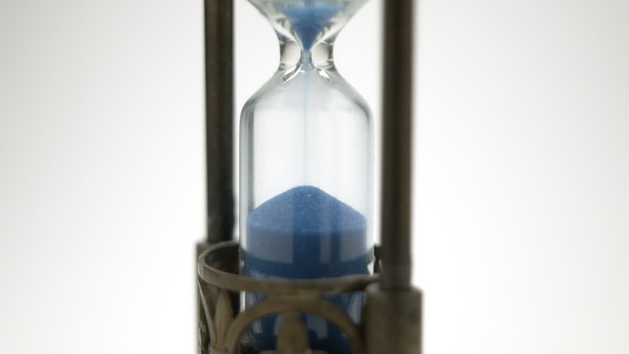 Old hourglass last grain of sand finishing countdown
