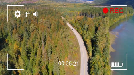 aerial view of winding road through forest with camera recording animation