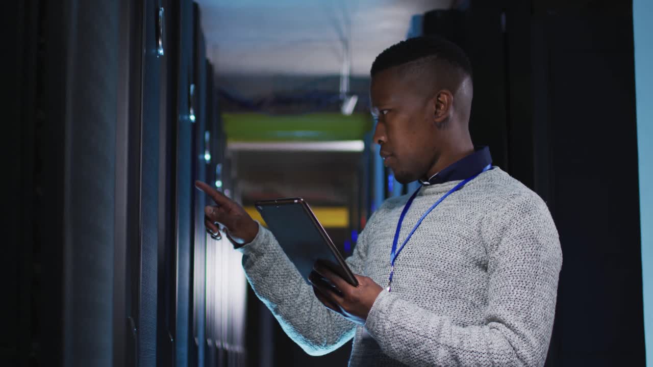 African american male computer technician using tablet working in business server room