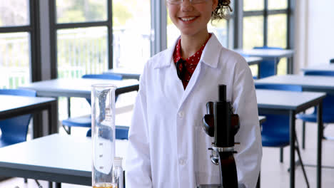 portrait of schoolgirl standing with various experiment equipments