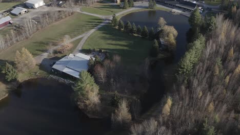 Drohnen-Luftaufnahme-Eines-Wunderschönen-Grundstücks-Mit-Einem-Großen-Teich-Und-Einer-Reihe-Alter-Gebäude-In-Der-Region-Ottawa